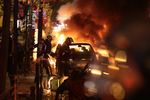 تلاش برای خاموش کردن آتش خودرو در جریان اعتراض‌های پاریس
