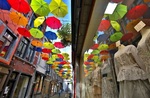 انعکاس چترهای رنگی در ویترین فروشگاه؛ نامور، بلژیک